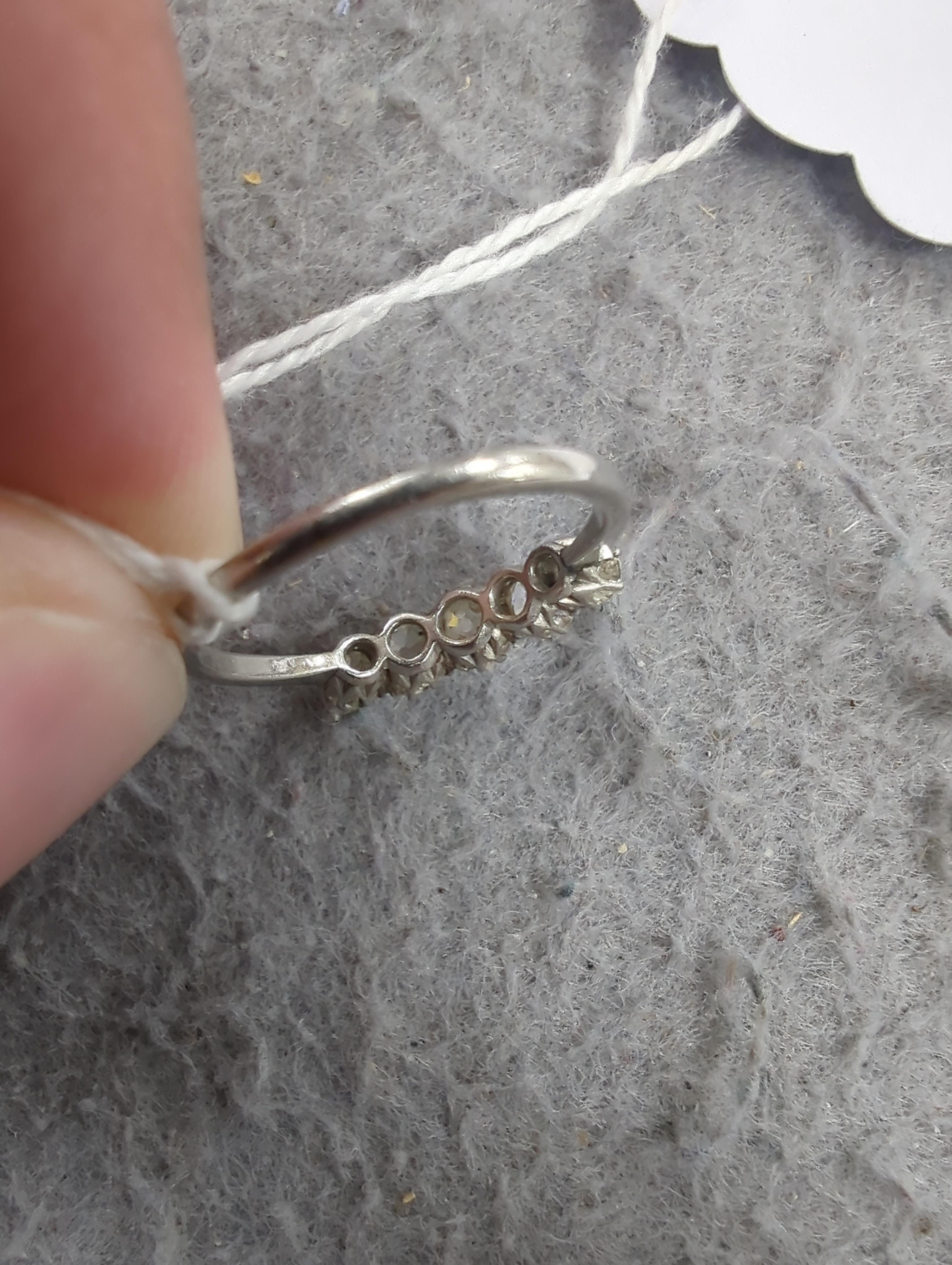 A 1940's white metal and graduated five stone diamond set half hoop ring, size M/N, gross weight 2.8 grams.